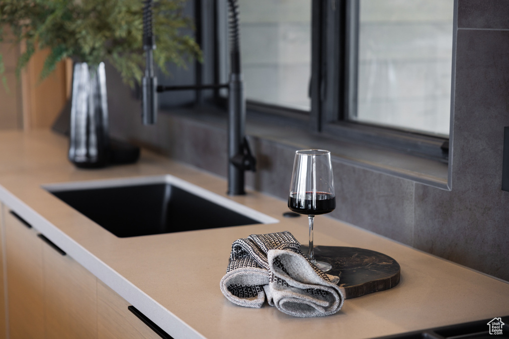 Kitchen view of a sink and light countertops