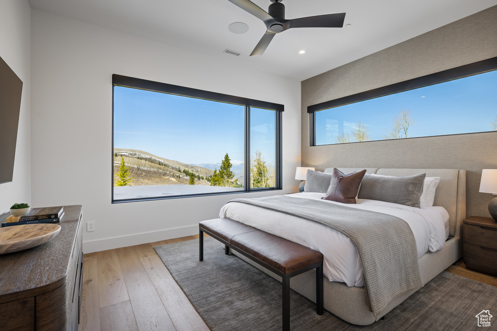Bedroom with hardwood / wood-style flooring, baseboards, multiple windows, recessed lighting, and ceiling fan