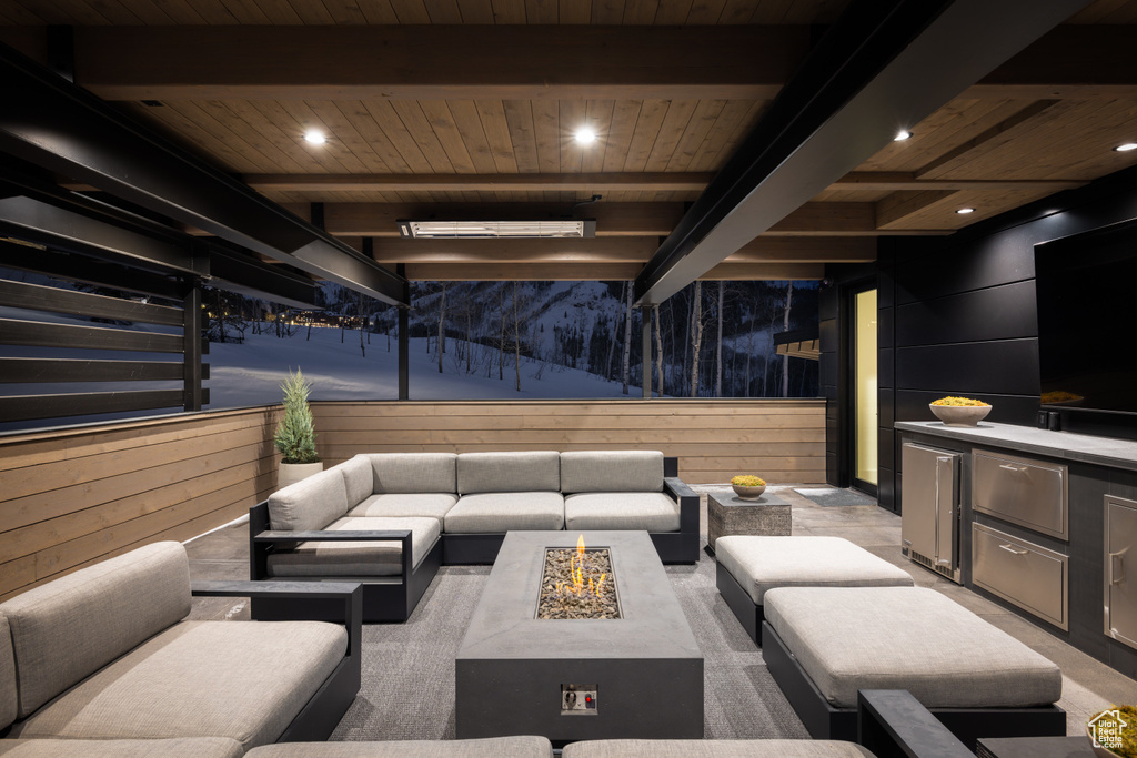 Common area featuring wooden ceiling with exposed beams, wooden walls, and recessed lighting