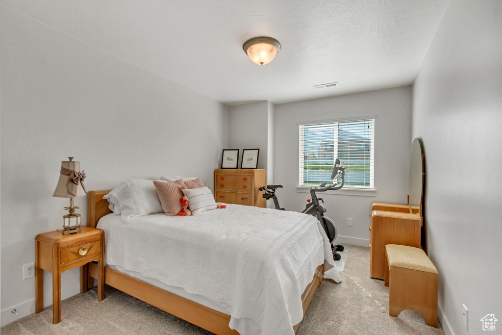 Bedroom with baseboards and light carpet