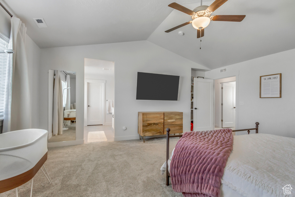 Carpeted bedroom featuring vaulted ceiling and ceiling fan