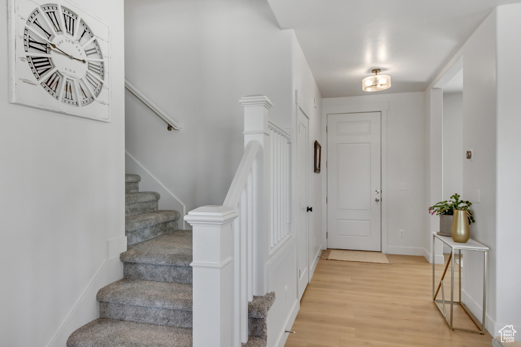 Entryway with light wood-style flooring, stairway, and baseboards
