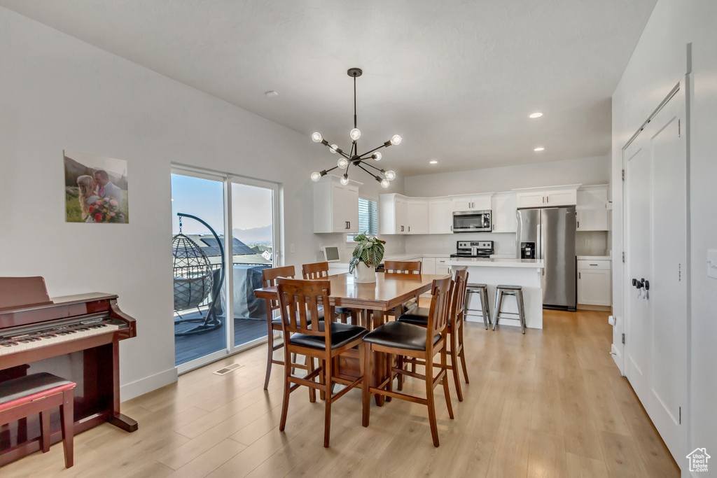 Dining room featuring light wood-style flooring, recessed lighting, a chandelier, and baseboards