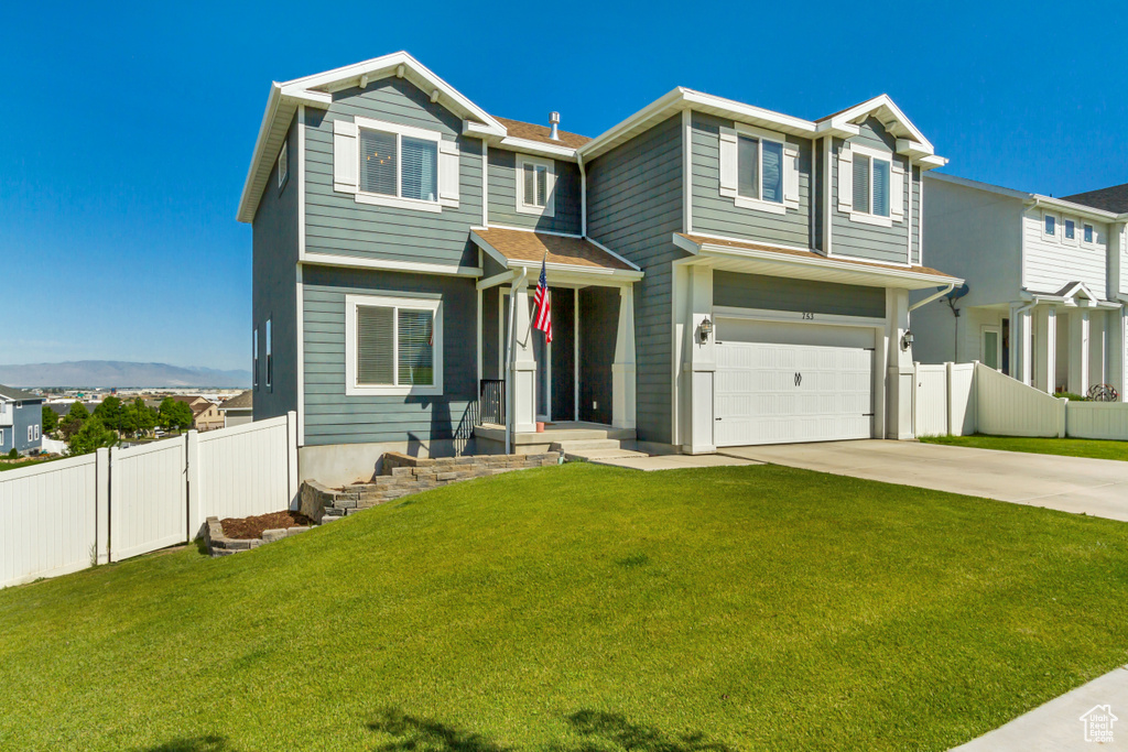 View of front of home with driveway and a garage