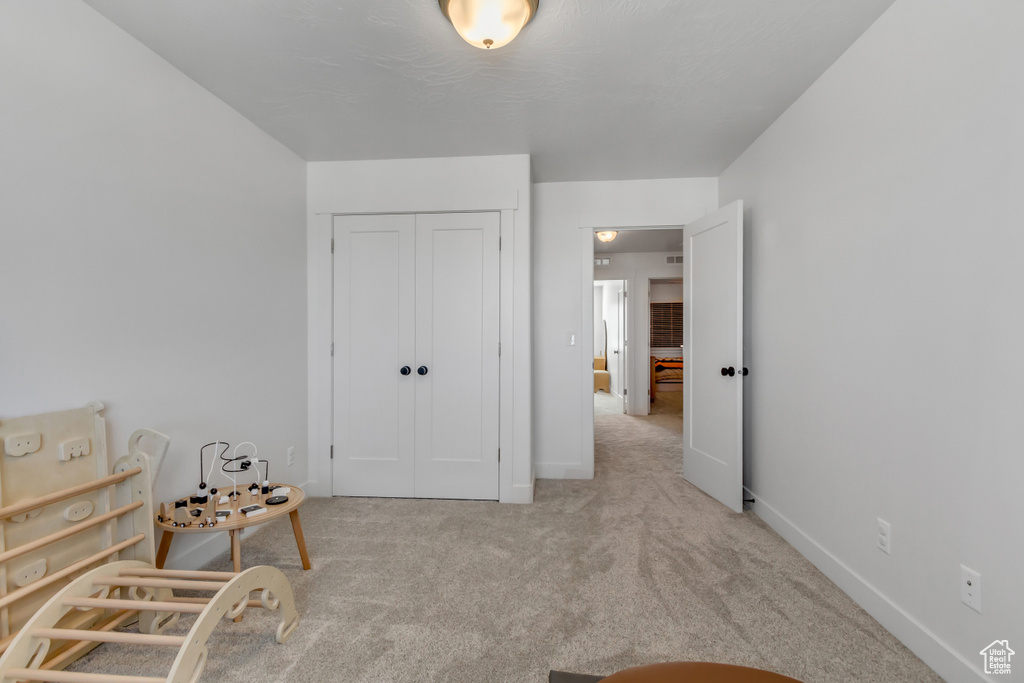 Carpeted bedroom featuring a closet and baseboards