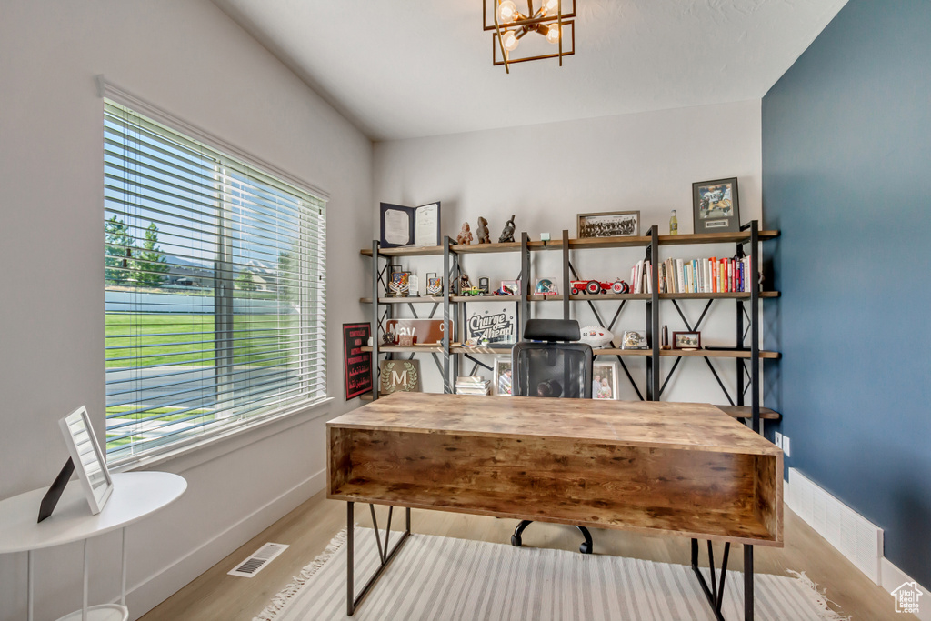 Office featuring healthy amount of natural light, baseboards, wood finished floors, and a chandelier