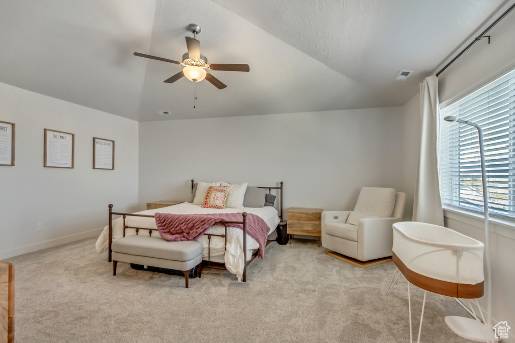Bedroom featuring vaulted ceiling, light colored carpet, ceiling fan, and baseboards