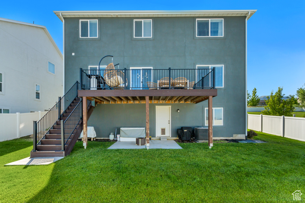 Back of property featuring stucco siding, a wooden deck, a patio area, and central air condition unit