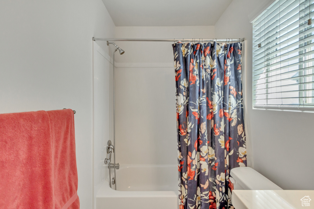 Bathroom featuring shower / bath combination with curtain and toilet
