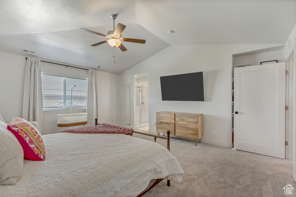 Carpeted bedroom featuring vaulted ceiling, baseboards, ceiling fan, and ensuite bath