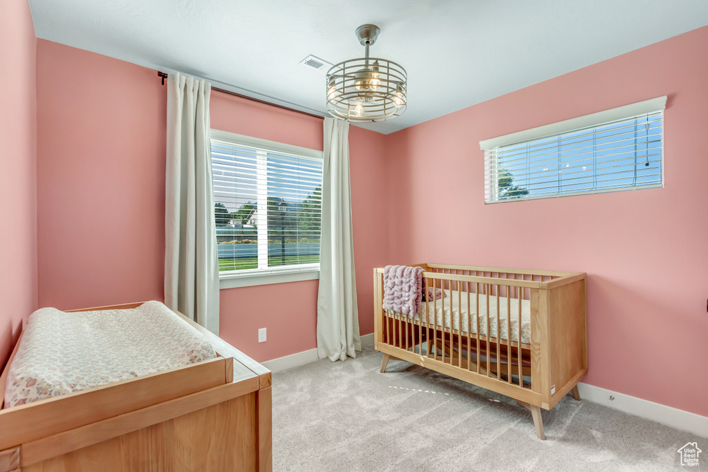 Bedroom with light carpet, multiple windows, and baseboards