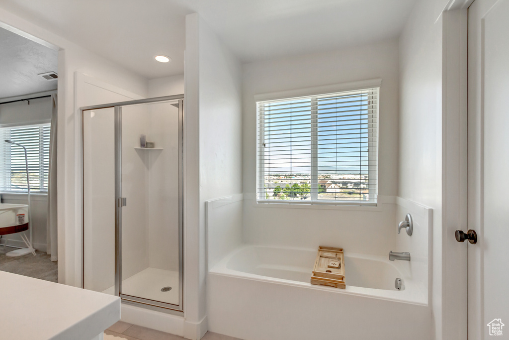 Full bathroom featuring a bath, a shower stall, plenty of natural light, and recessed lighting
