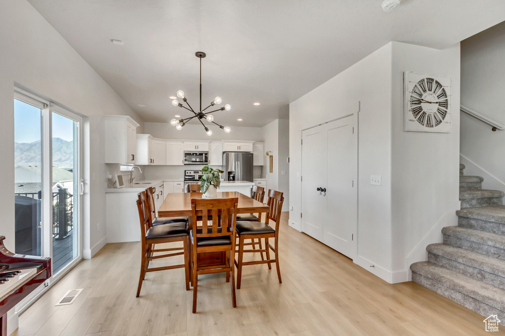 Dining room featuring a chandelier, stairs, light wood-style floors, baseboards, and recessed lighting