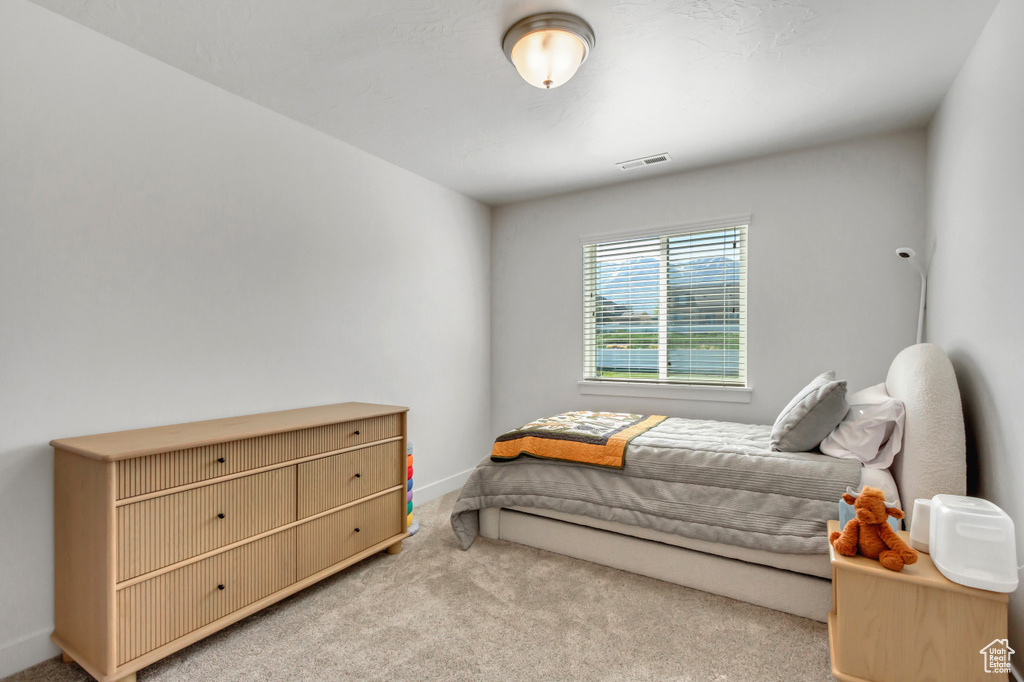 Bedroom with light carpet and baseboards