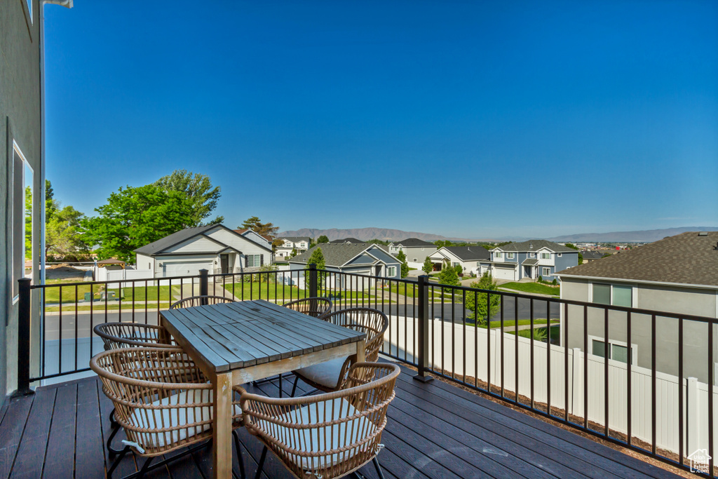 Wooden deck featuring a residential view, outdoor dining space, and a mountain view