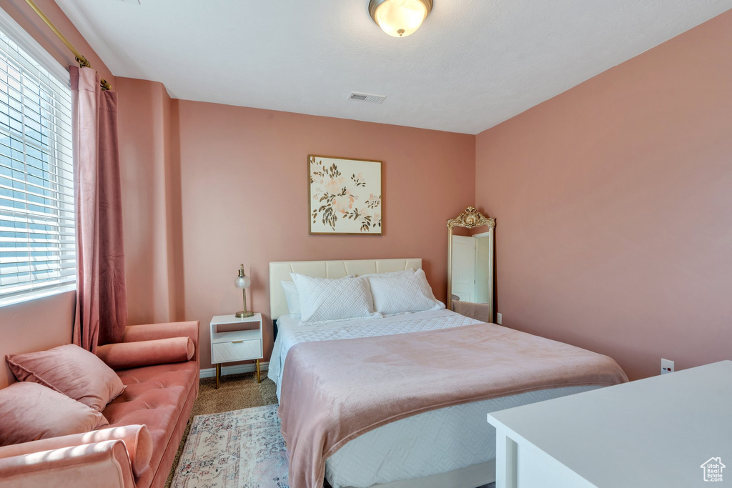 Bedroom with multiple windows and carpet flooring