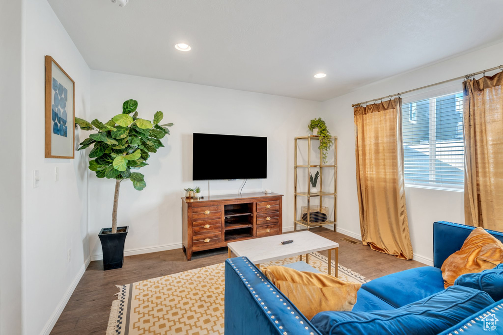 Living area with wood finished floors, baseboards, and recessed lighting