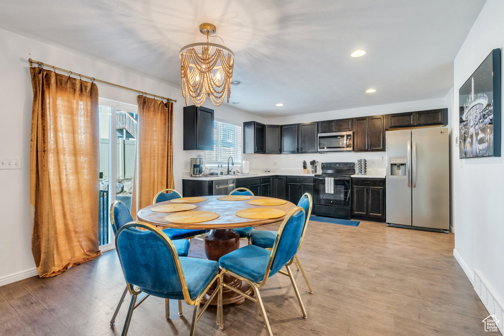 Dining area featuring a chandelier, light wood-style floors, recessed lighting, and baseboards