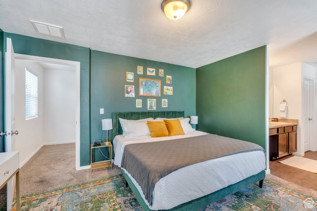 Bedroom featuring baseboards, a textured ceiling, and a sink