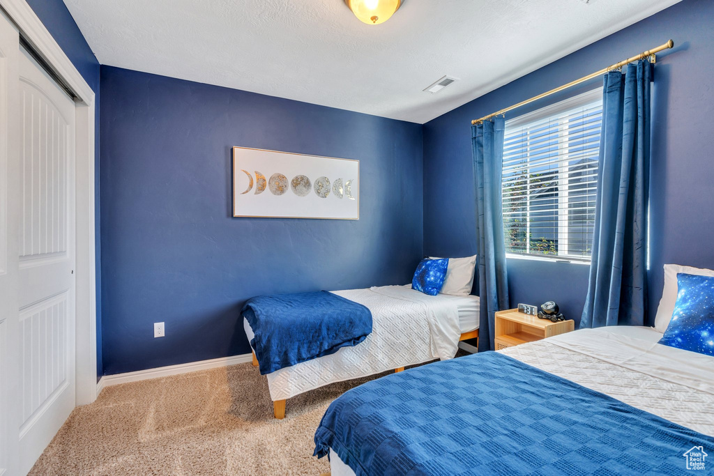 Carpeted bedroom featuring baseboards and a closet