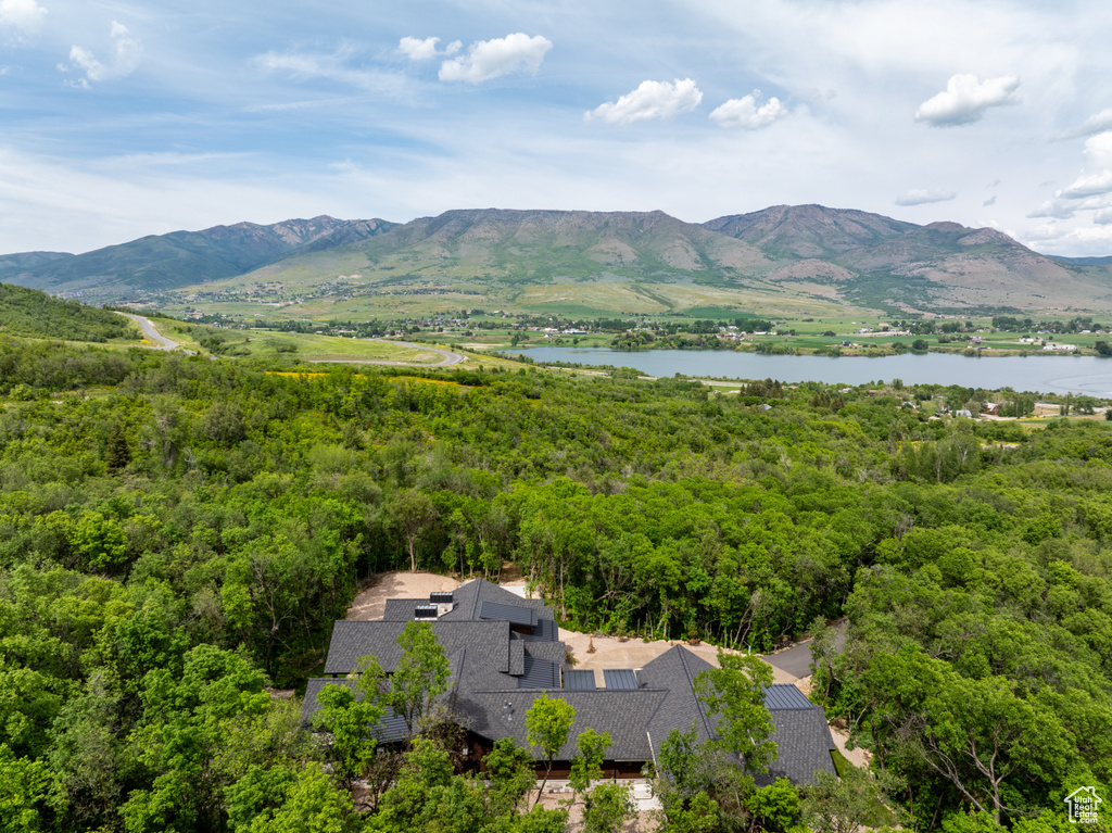 View of mountain backdrop with a nearby body of water and a heavily wooded area
