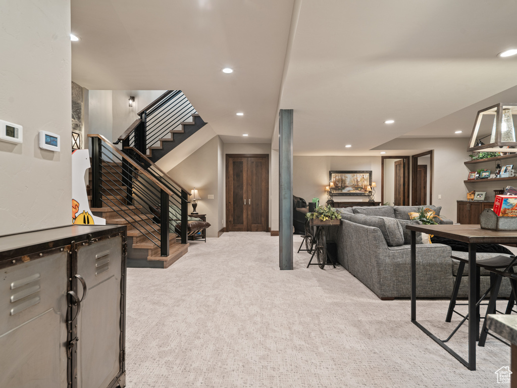 Carpeted living room featuring recessed lighting and stairs