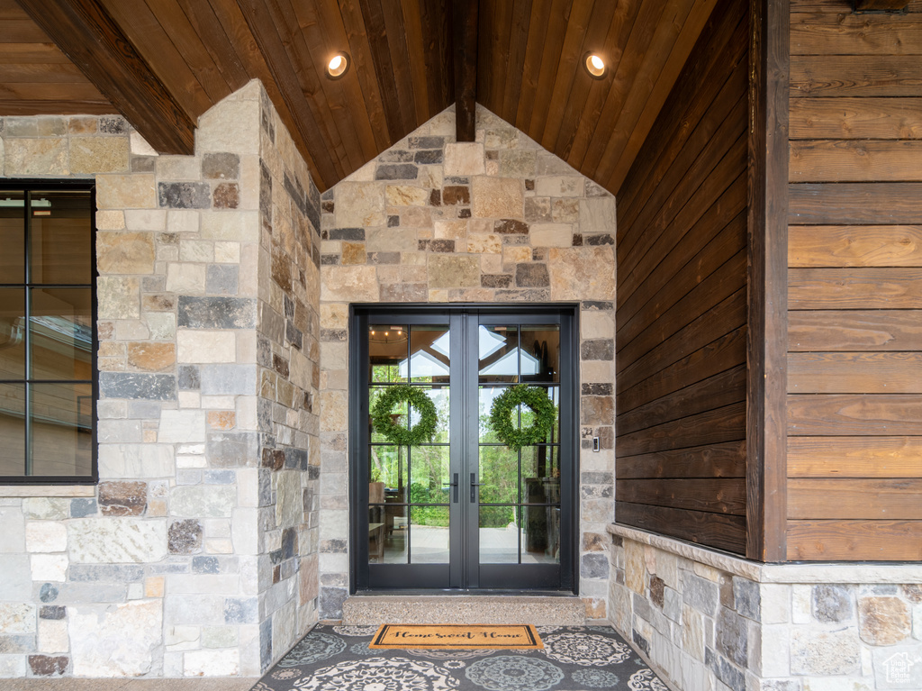 View of exterior entry with french doors and stone siding