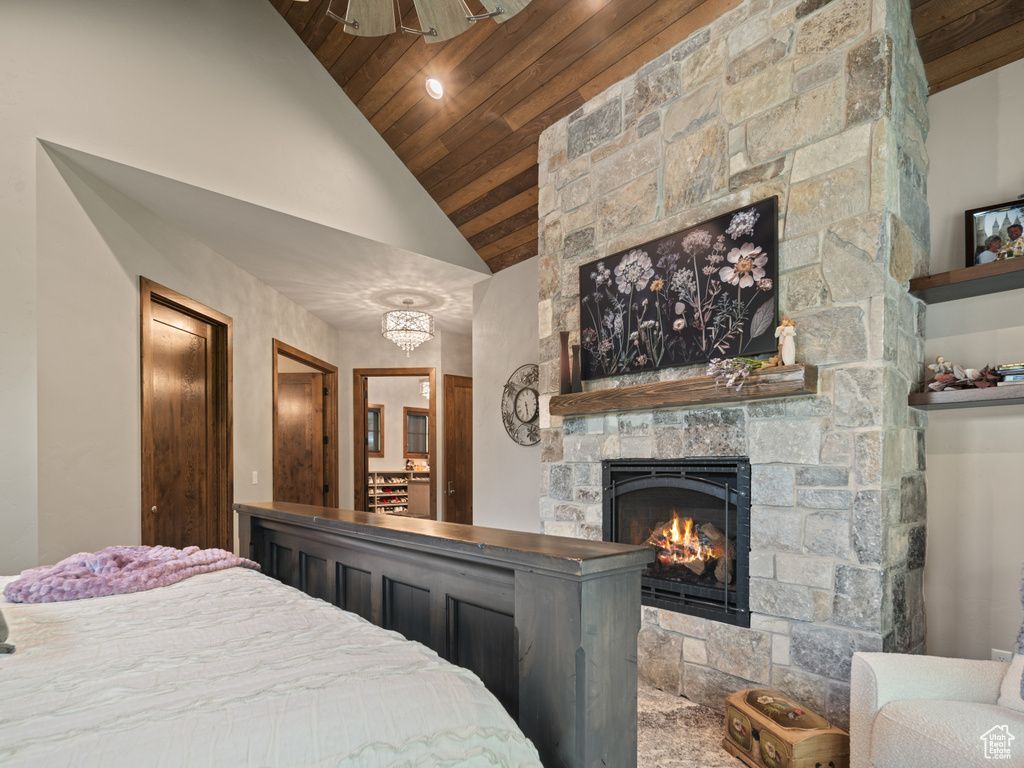 Bedroom featuring wood ceiling, a stone fireplace, and high vaulted ceiling