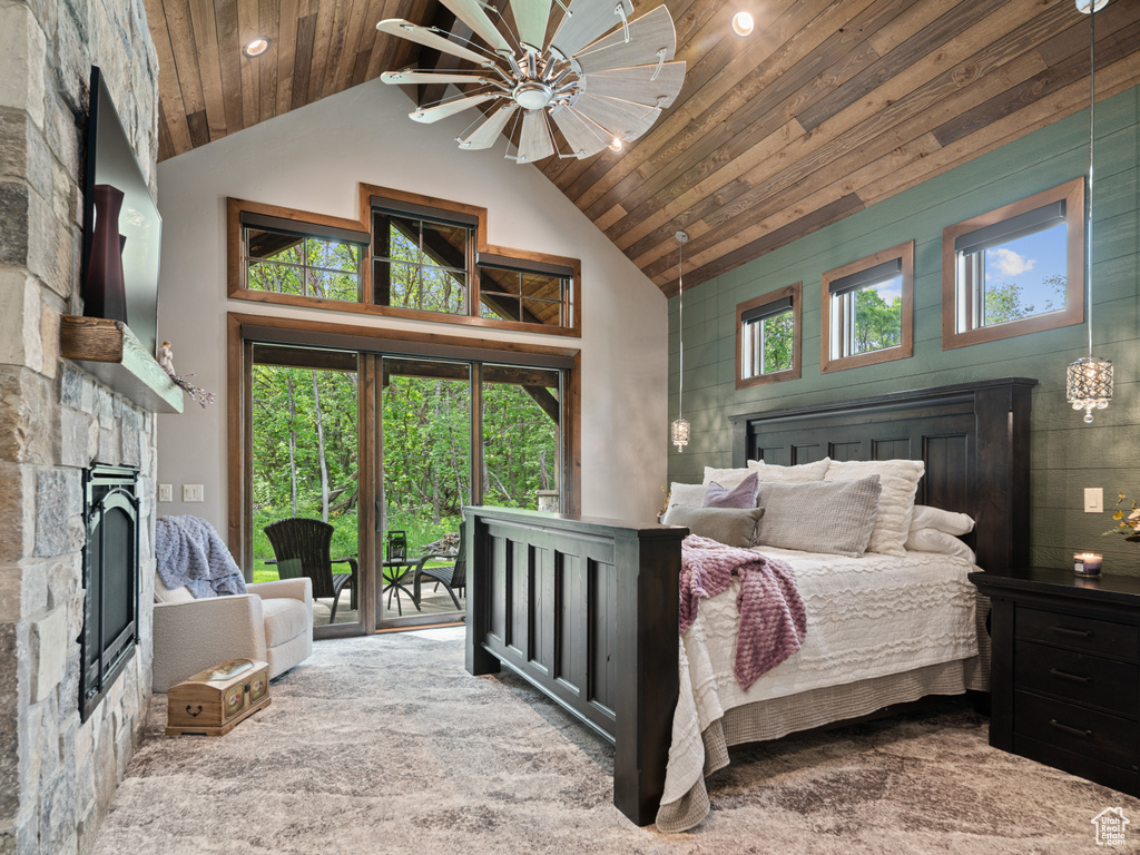 Bedroom with a stone fireplace, access to outside, high vaulted ceiling, wooden ceiling, and recessed lighting