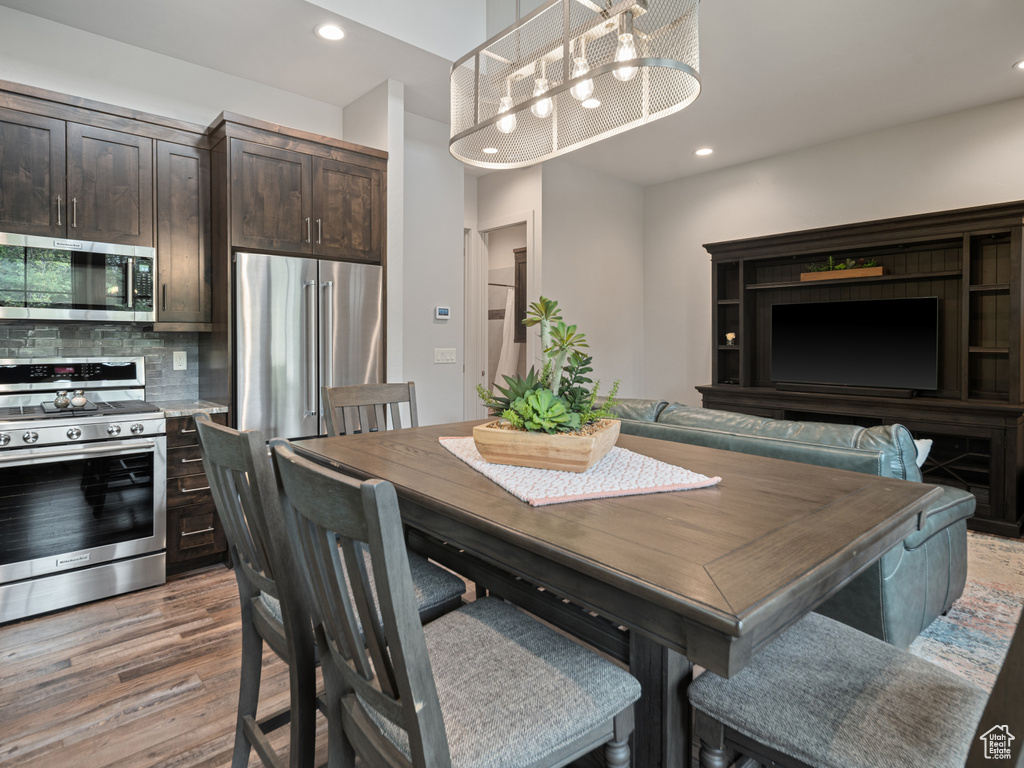 Dining area with light wood-style floors and recessed lighting