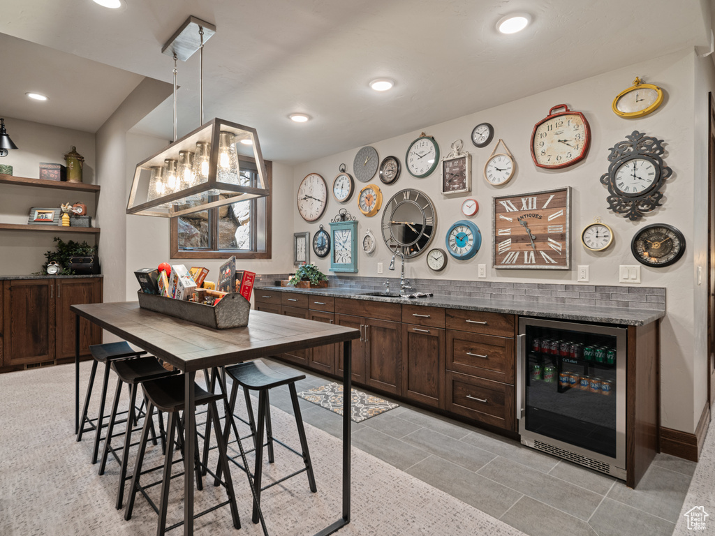 Indoor dry bar with wine cooler, hanging light fixtures, recessed lighting, and light tile patterned flooring