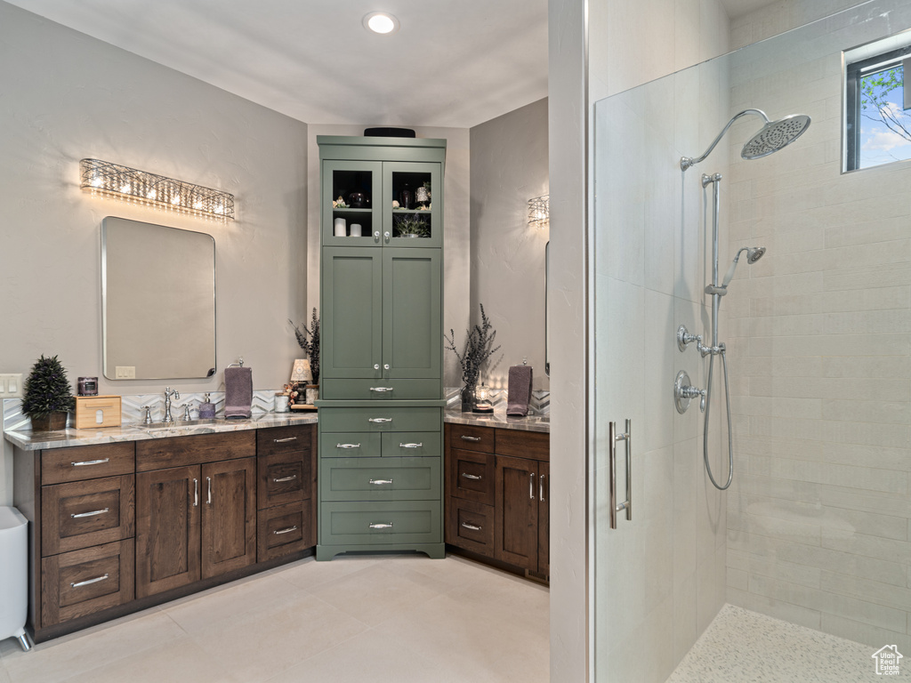 Bathroom featuring a tile shower and vanity