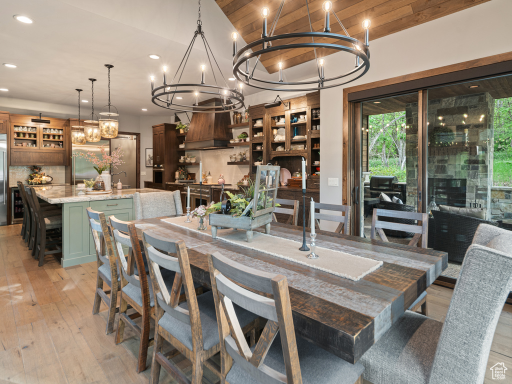 Dining room with a chandelier, recessed lighting, light wood-style flooring, lofted ceiling, and wood ceiling