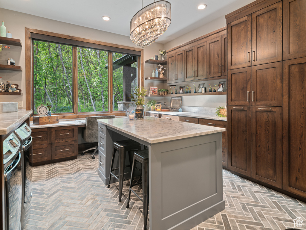 Kitchen with open shelves, a kitchen bar, a kitchen island, an office area, and recessed lighting