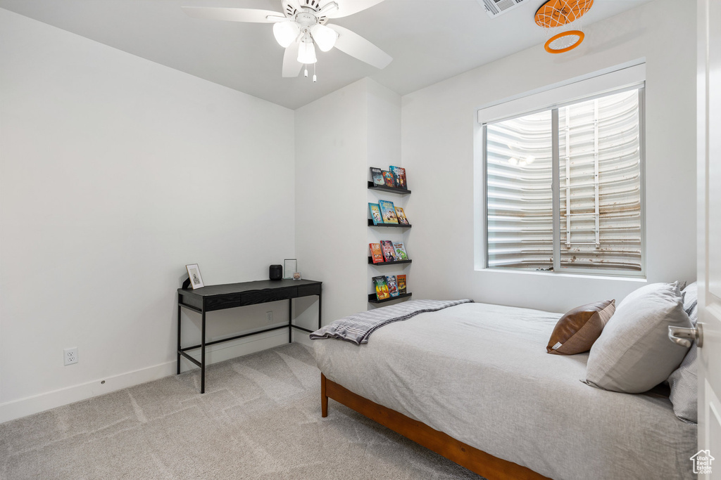 Carpeted bedroom featuring baseboards and ceiling fan