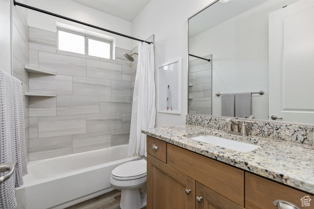 Bathroom with shower / tub combo with curtain, vanity, toilet, and wood finished floors