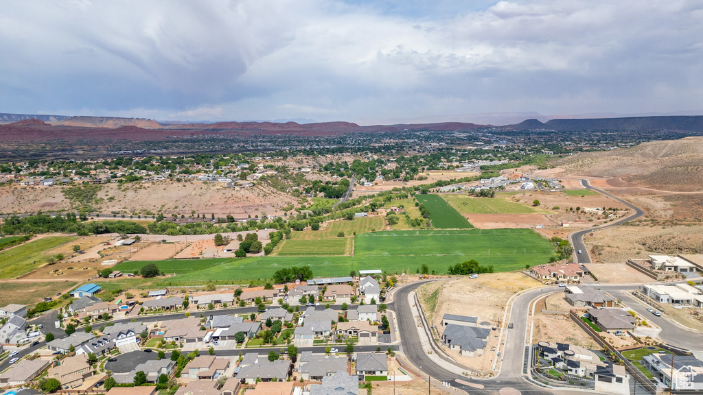 Aerial view of property and surrounding area featuring mountains and nearby suburban area