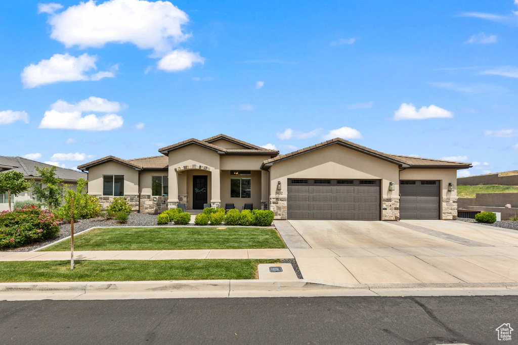 View of front of property with stone siding, a garage, and stucco siding