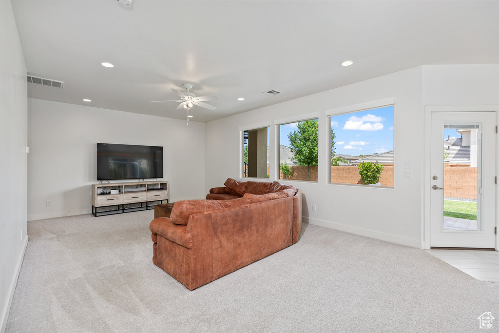 Living room with light carpet, baseboards, recessed lighting, and a ceiling fan