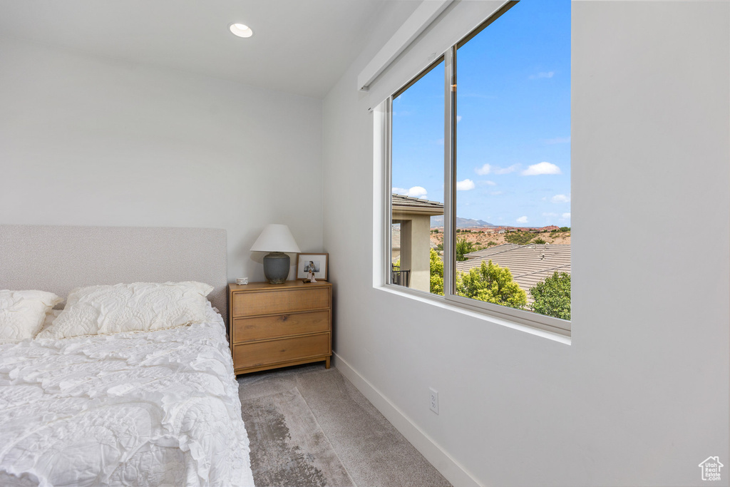 Bedroom featuring baseboards, multiple windows, and carpet