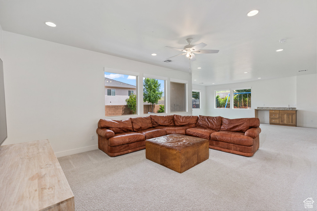 Carpeted living room with recessed lighting, ceiling fan, and baseboards