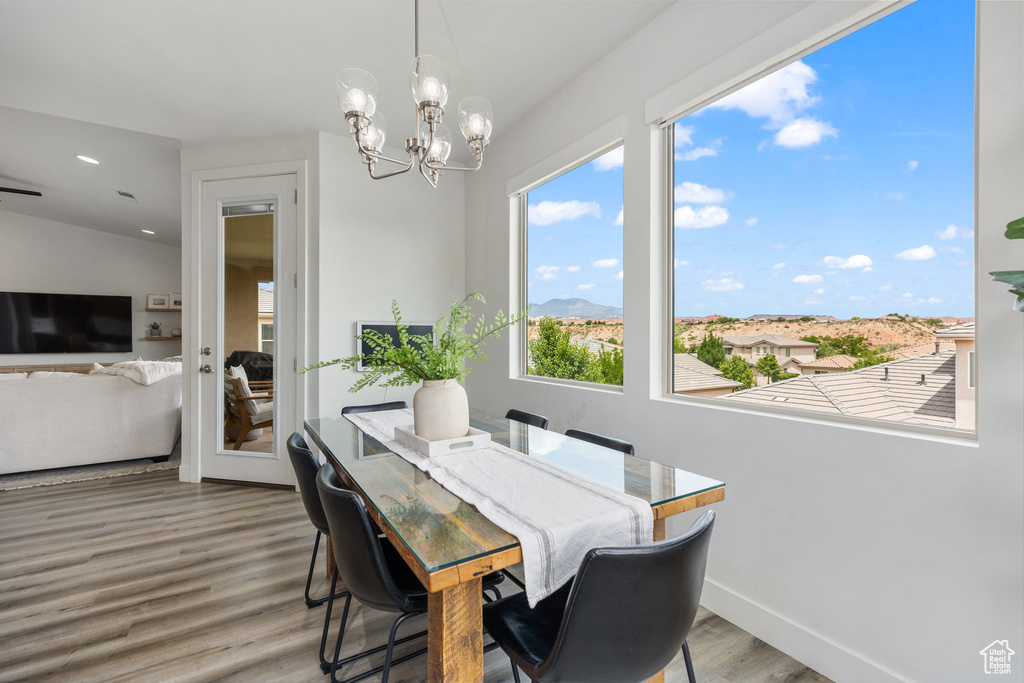 Dining area featuring wood finished floors, a chandelier, baseboards, and recessed lighting