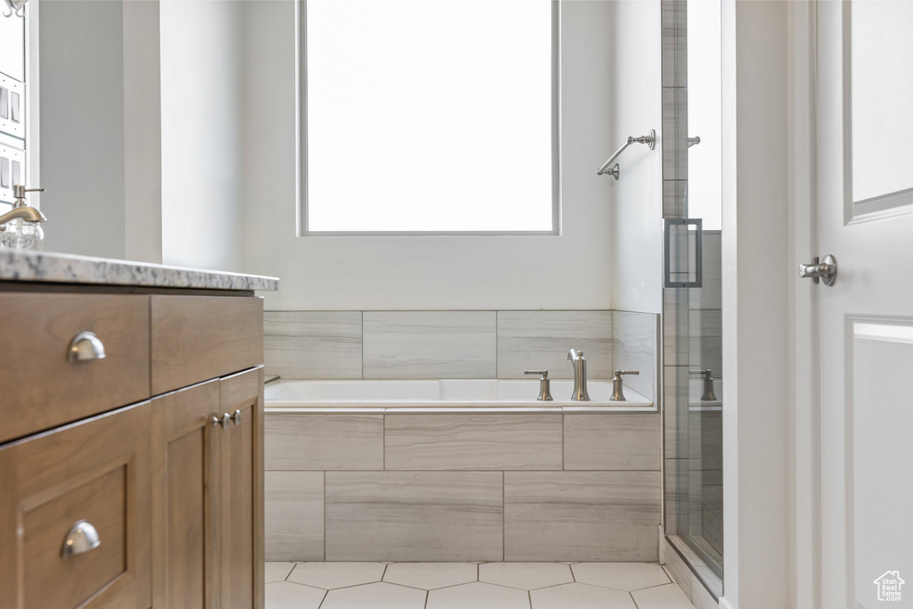 Bathroom featuring vanity, a bath, a stall shower, and tile patterned flooring