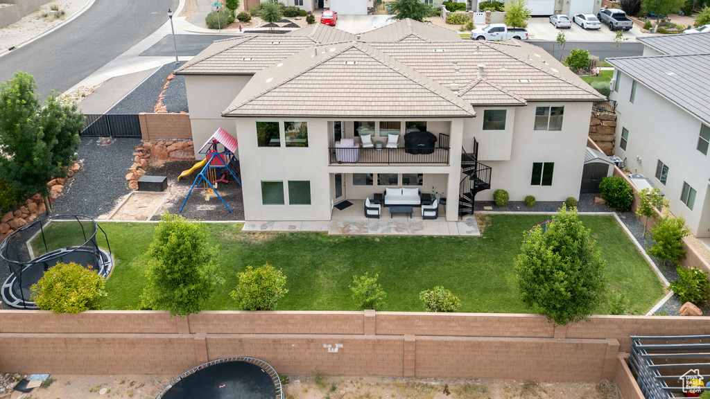 Back of property featuring a patio area, stucco siding, an outdoor hangout area, and a balcony