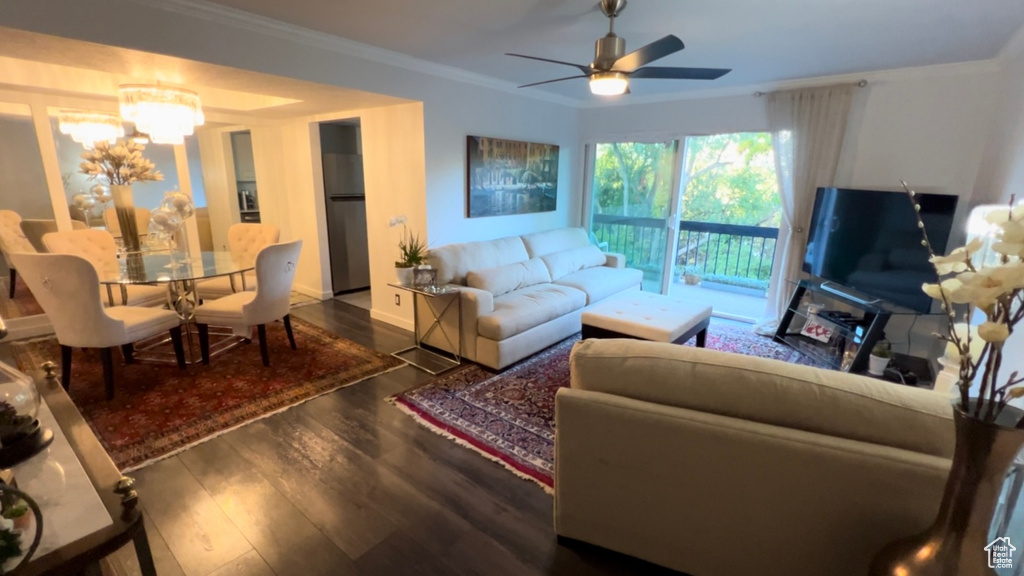 Living area featuring wood finished floors, ornamental molding, a chandelier, and a ceiling fan