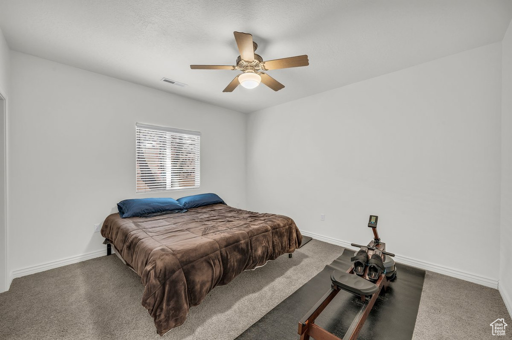 Carpeted bedroom featuring baseboards and a ceiling fan