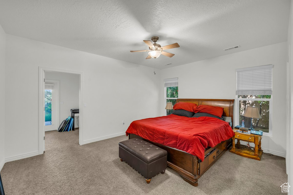 Bedroom with carpet floors, a textured ceiling, baseboards, and a ceiling fan