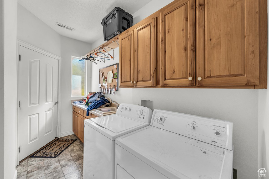 Laundry room with washing machine and clothes dryer and cabinet space