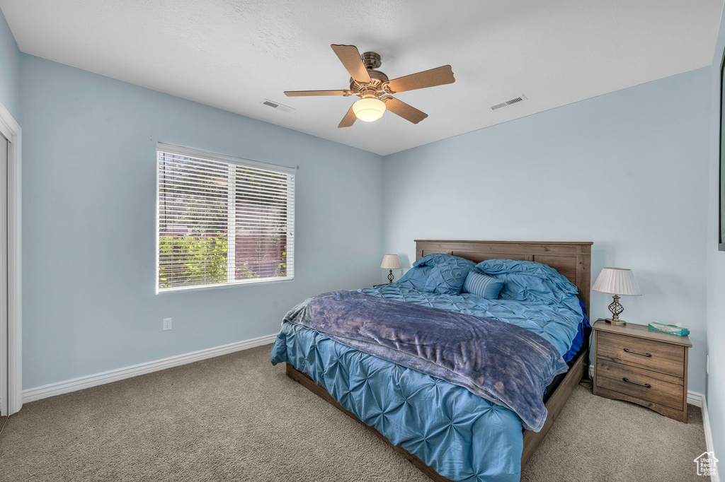 Bedroom featuring carpet floors, baseboards, and a ceiling fan