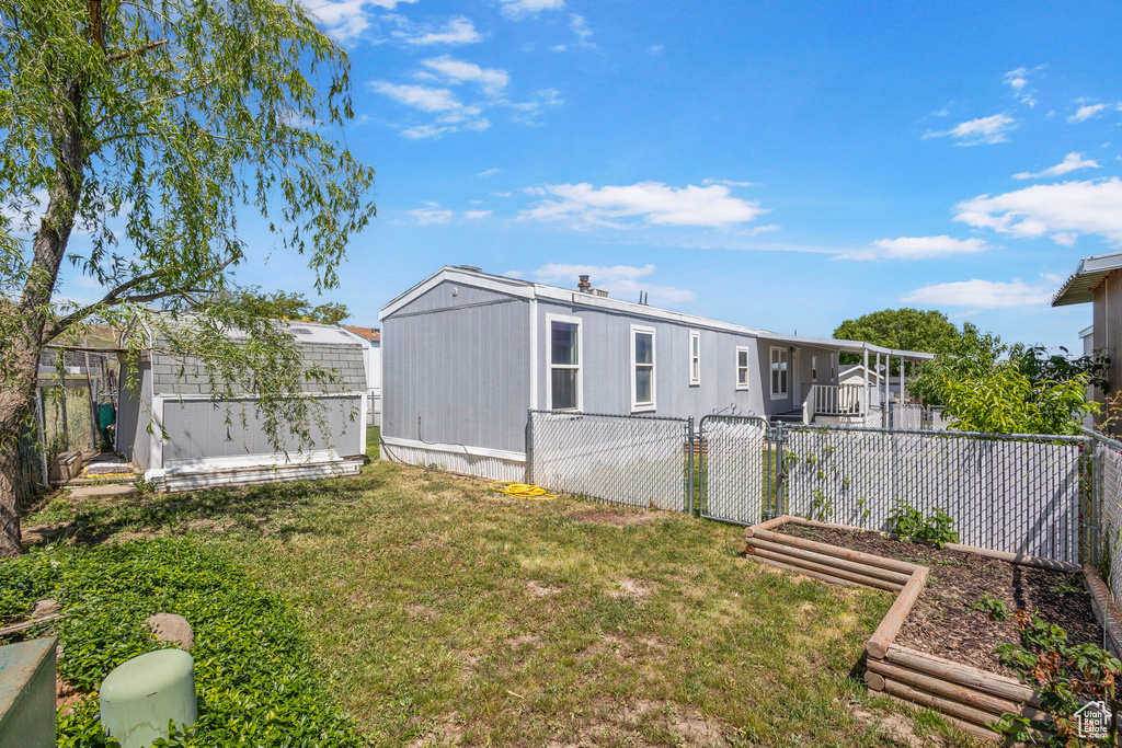 Rear view of house featuring a vegetable garden and a gate